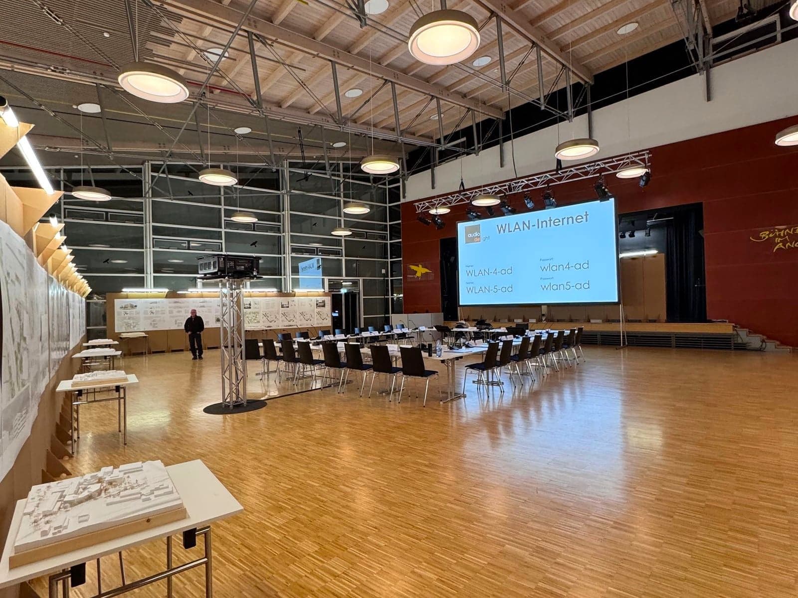 Preisgerichtssitzung mit Leinwand und Modellpodesten