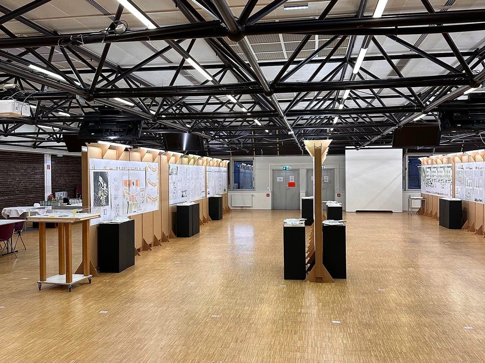Stellwandreihe mit Modellpodesten unter Stahlträgerdach